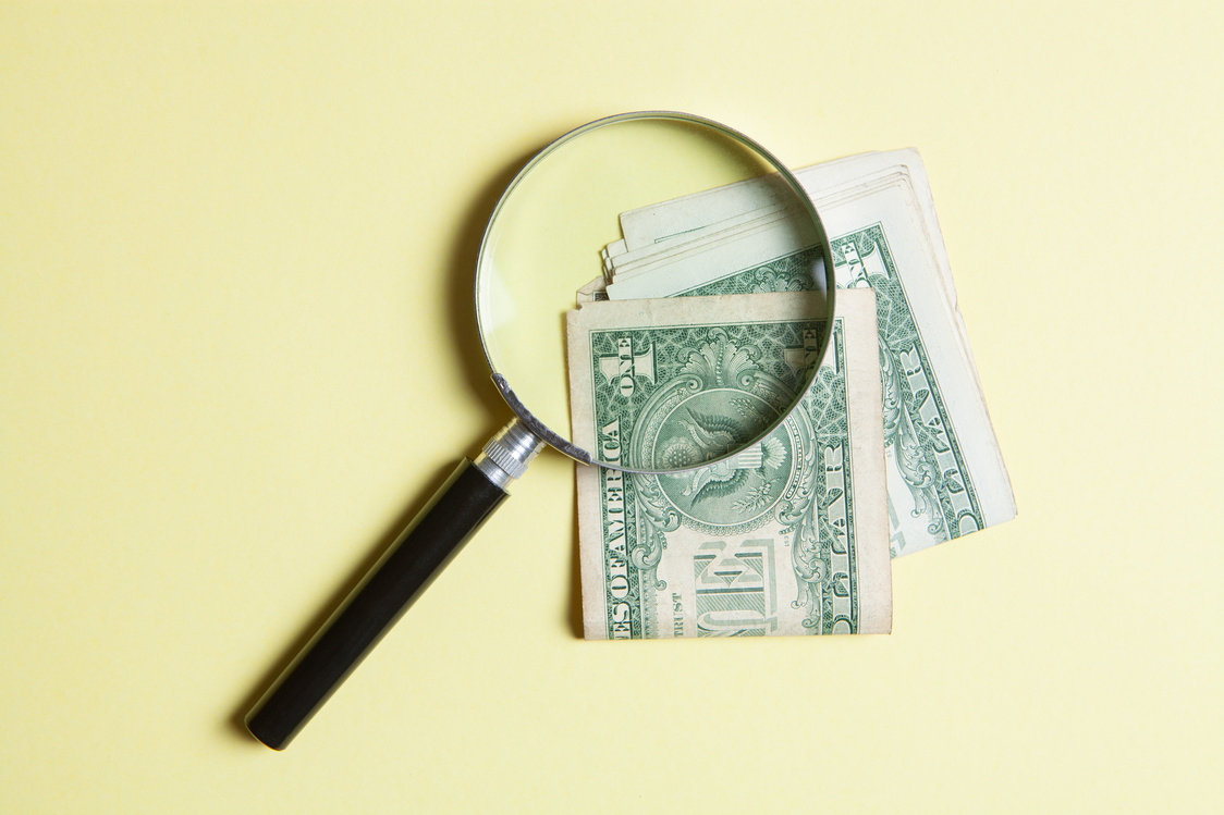magnifying glass and money on a yellow background